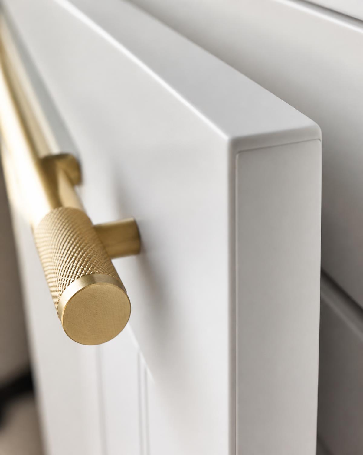 Detail of a sprayed cabinet edge and brass hardware